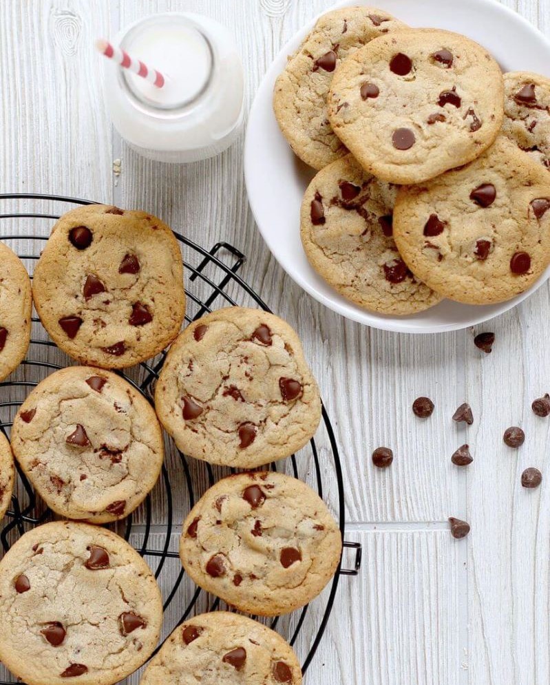 Baked Wooden Spoon Chocolate Chip Cookies on a cooling rack. More cookies are on a plate next to the rack.