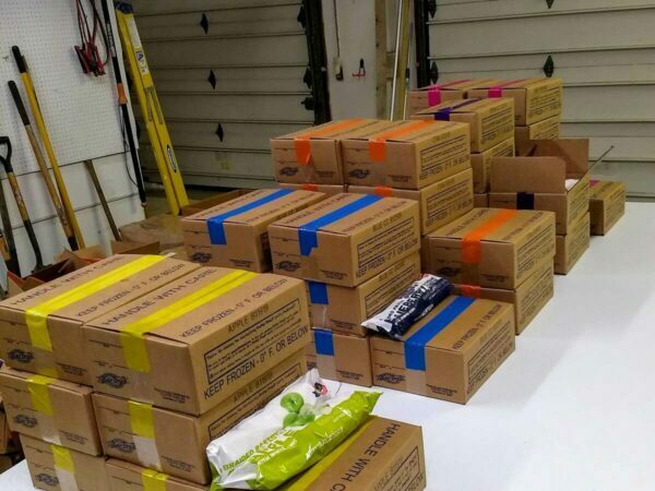 Several boxes with pastries laid out on a table for sorting.