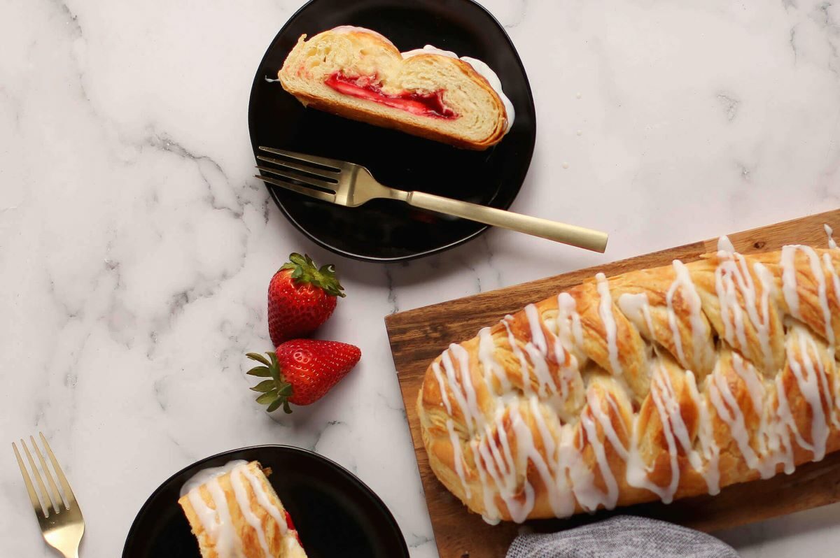 Strawberry & Cream Cheese pastry next to two plates with a slice of pastry on each.